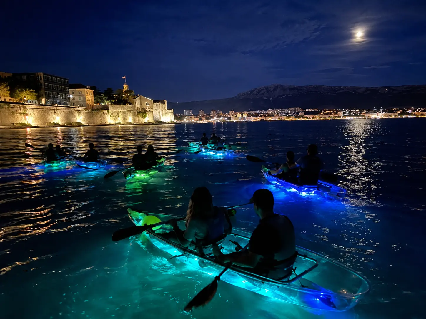 Sea kayakers paddling below the pine-covered limestone cliffs of Marjan hill near Split, Croatia