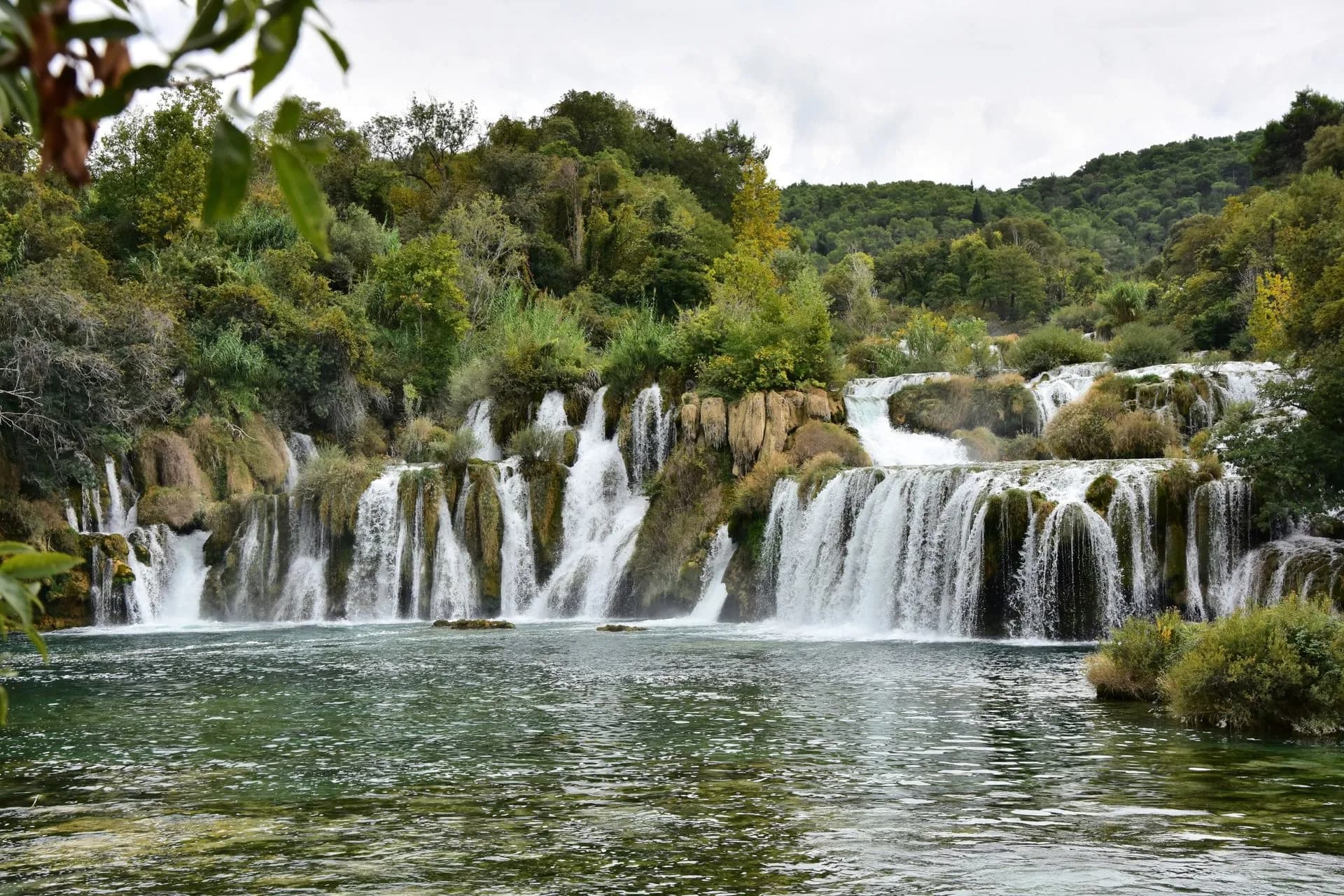 Skradinski Buk waterfall cascading over travertine barriers into a green pool in Krka National Park