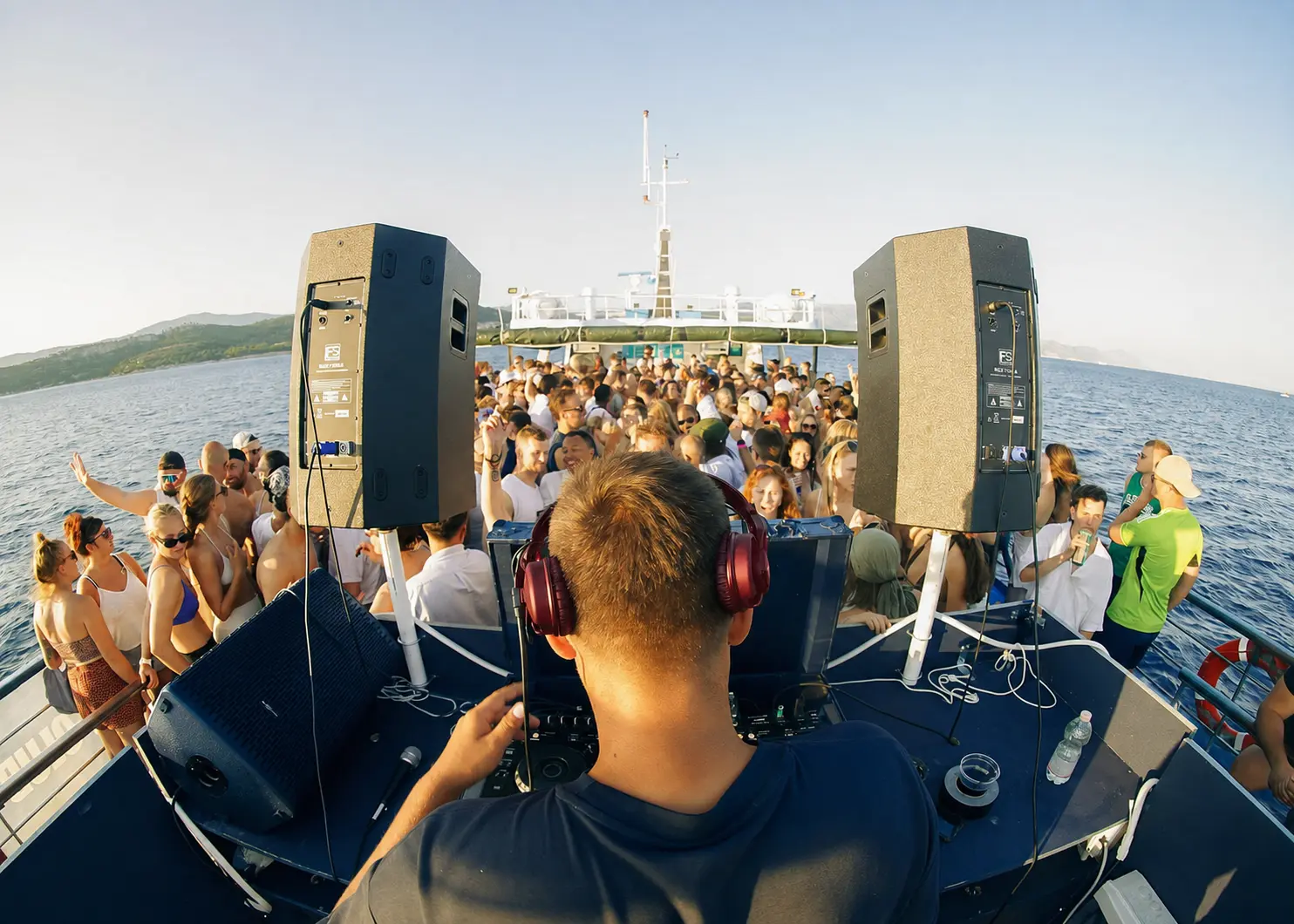 Crowd dancing on the open deck of a party boat anchored at the Blue Lagoon near Split, Croatia