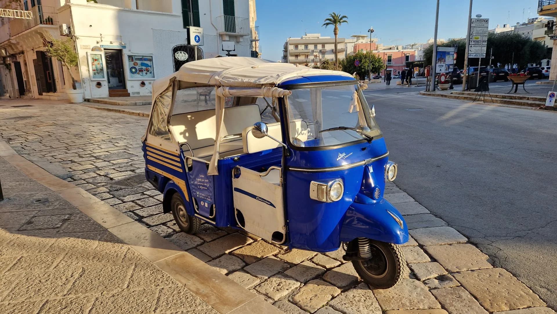 Open-sided electric tuk tuk carrying passengers along the Riva waterfront promenade in Split