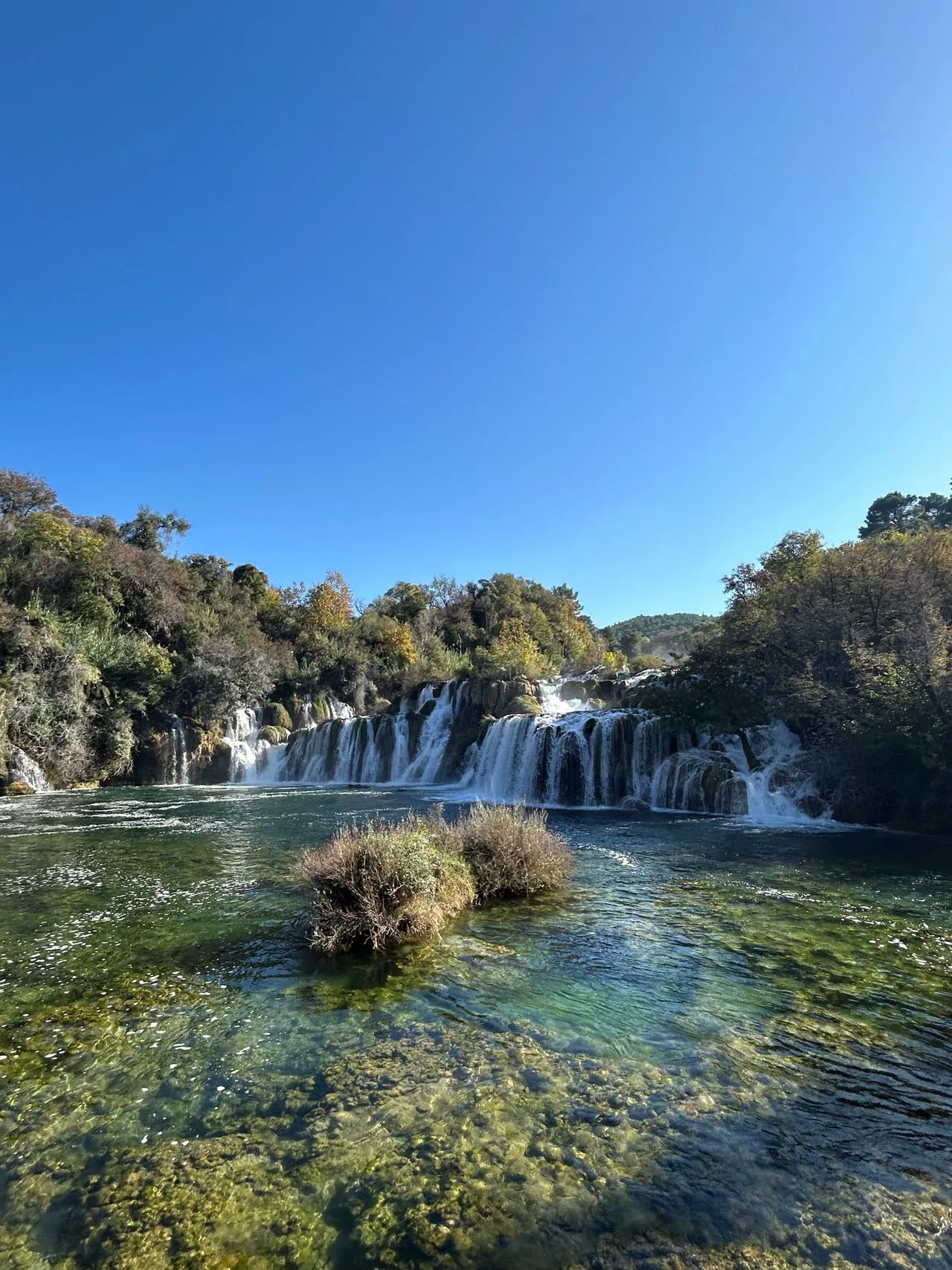 Skradinski Buk waterfall spilling over travertine barriers into clear shallow pools in Krka National Park